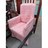 An Edwardian small upholstered arm chair raised upon turned legs and pad feet