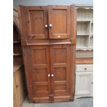 A Georgian pine four drawer corner cupboard with shaped shelved interior,