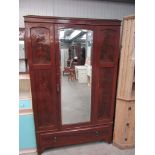 An Edwardian mahogany wardrobe, central bevelled mirror door flanked by flamed panels,