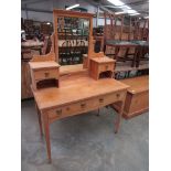 An Edwardian pine dressing table with mirror back, two frieze drawers,