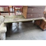 A pine trestle table with metal folding legs,