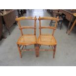 A pair of early 20th Century beech and cane seated bedroom chairs