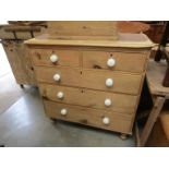 A Victorian pine two over three chest of drawers with porcelain handles