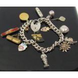 A silver charm bracelet hung with various charms including penknives,