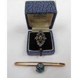 A bar brooch set with an oval turquoise coloured glass cabochon,