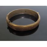 A silver stiff hinge bangle, engraved decoration, Chester 1953, slightly dented and surface dirt,