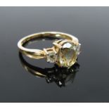 A 9ct gold ring the central pale green oval stone flanked by diamonds .20ct total. Size O, 2.