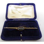 A gold bar brooch with three round aquamarines .20ct each in halo mount, 7cm long stamped 15ct, 4.