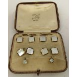 A set of dress studs of canted squares of mother-of-pearl with gold and black enamel line borders