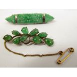 A carved Jade panel brooch stamped 9ct 5528, 6cm long and a cabochon frond form brooch,