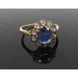 A gold sapphire and diamond ring the central sapphire 8mm x 6mm framed by 10 old cut diaomds .