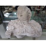 A rough-moulded plaster bust of a cherub. 29cm tall. Repaired.