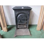 A 19th Century cast iron bedroom fire insert with door and set on iron base.