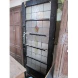 A painted wood front door set with five panels of stained glass depicting a stylised tulip.