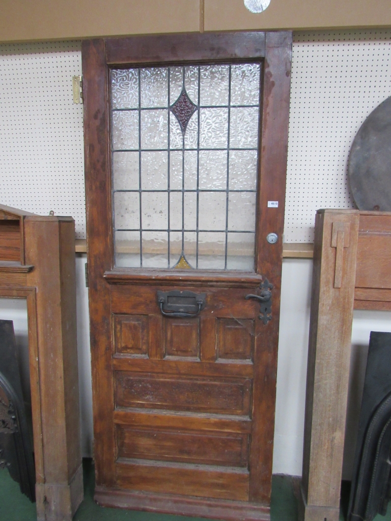 A wooden stained glass front door with coloured sections and door furniture.