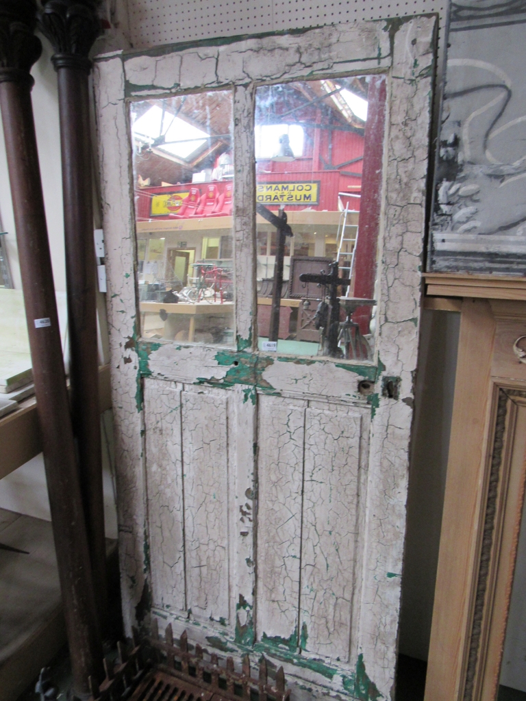 A rustic door with two mirrored glass panels.