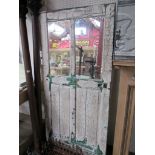 A rustic door with two mirrored glass panels.