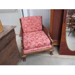 A walnut bergere armchair on carved ball in claw feet