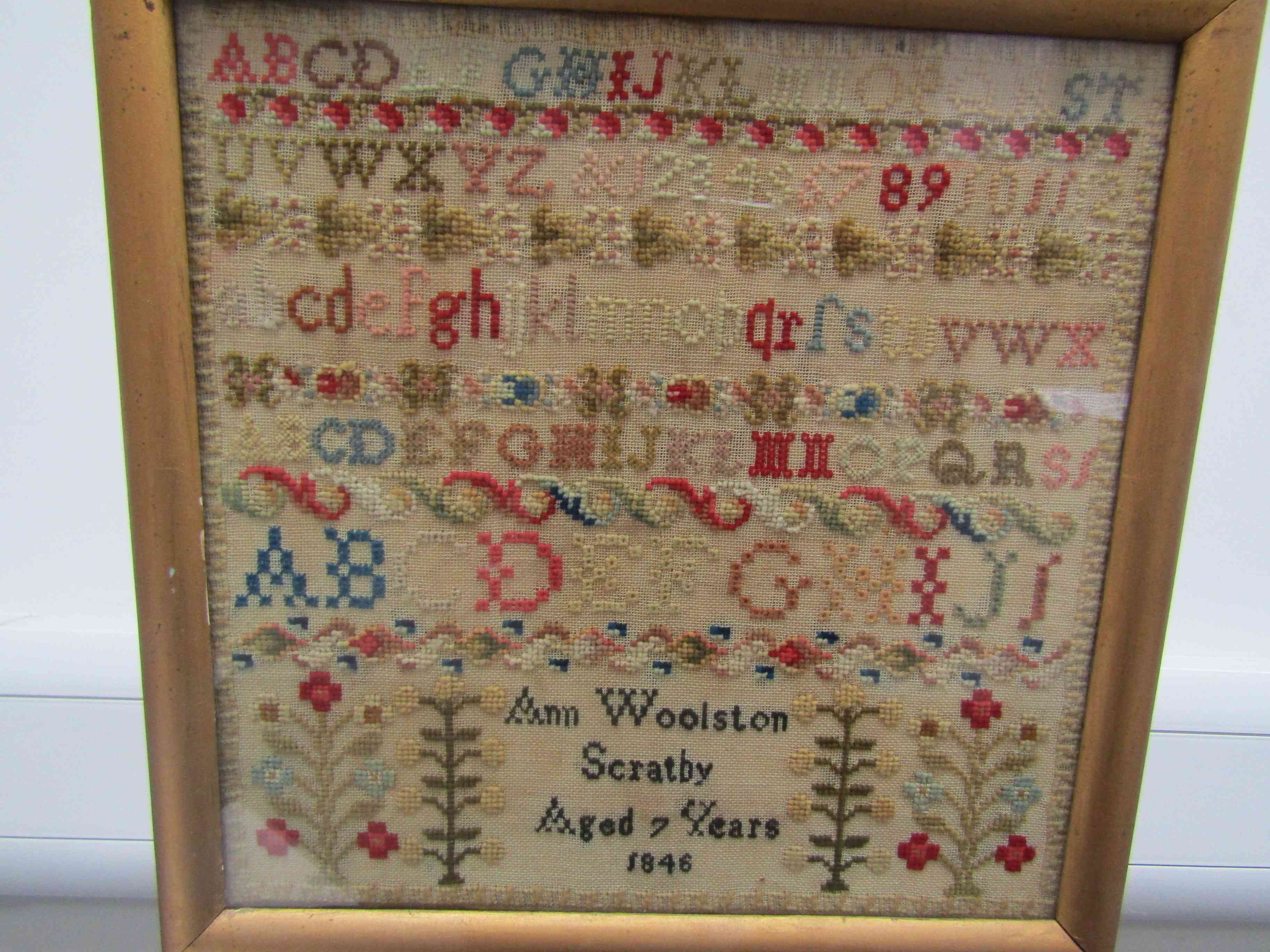 A Victorian woolwork mixed-stitch sampler by "Ann Woolston, Scratby, Aged 7 Years, 1846",