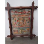 A Victorian sampler worked in brightly coloured wools on a canvas ground with cases of the alphabet,