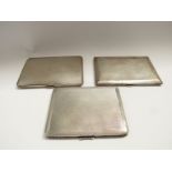 Three silver cigarette cases all with engine turned decoration, Birmingham 1928, 1931 and 1947,