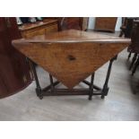 An 18th Century mahogany corner drop-leaf breakfast table raised upon tapering turned legs and
