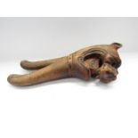 A pair of wooden "lion head" nut crackers, one eye missing,