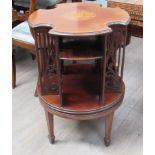 An Edwardian inlaid mahogany revolving bookcase of quatrefoil form with fret-cut dividers between