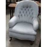 A late Victorian buttoned back upholstered chair on turned front legs
