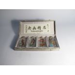 A cased set of early 20th Century Oriental glass encased hand-painted scent bottles with cabochon