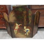 A three fold hand painted fire screen with scenes of putti in woodland,