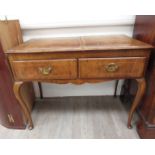 A Georgian walnut lowboy with two frieze drawers on slender cabriole legs.