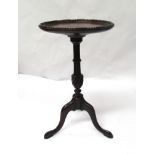 An Edwardian mahogany dish top wine table with shaped edge over a turned and wrythen coloumn on
