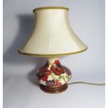 A Moorcroft Trial floral pattern table lamp, cream ground with hibiscus type red/purple flowers,
