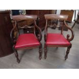 A pair of early Victorian mahogany open-arm dining chairs with drop-in seats