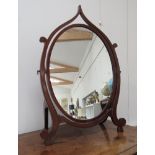 An Art Nouveau mahogany oval free-standing dressing-table swing mirror.