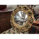 A gilt plaster wall decoration, a convex mirror and a plaster wall bracket,