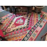 A red ground Kilim, brightly coloured geometric motifs, with single central diamond, fringing,