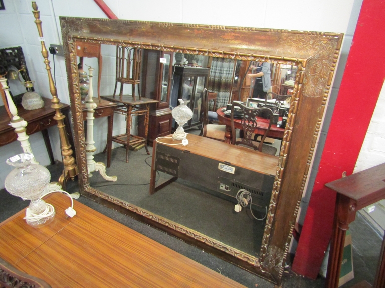 A large gilt framed mirror with foliate scrolled design 140x168 cm