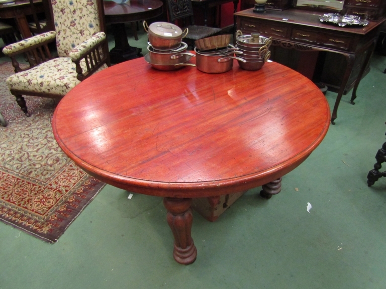 A Victorian mahogany circular dining table on melon-fluted legs to castors,