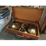 A vintage suitcase with brass ware contents