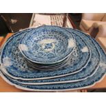 A set of three graduating blue and white serving plates and a selection of plates and dishes