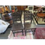 A pair of Victorian Jacobean revival carved oak hall chairs on turned legs