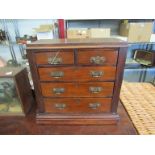 A mahogany two over three drawer collectors chest with keys,
