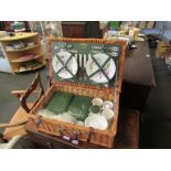 A wicker picnic hamper with four place settings