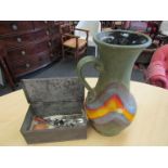 A tin box containing bijouterie and a lava glaze jug