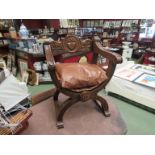 An oak savranola 'X' frame chair with carved decoration and leather seat,