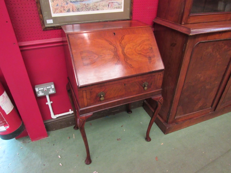 A Georgian style crossbanded figured walnut writing bureau the fitted interior and pull down fall