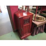 A late Victorian walnut bedside cupboard the carved raised back over a single door on a plinth base,