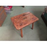 An 18th Century elm and oak stool with fret handle over chamfered legs,